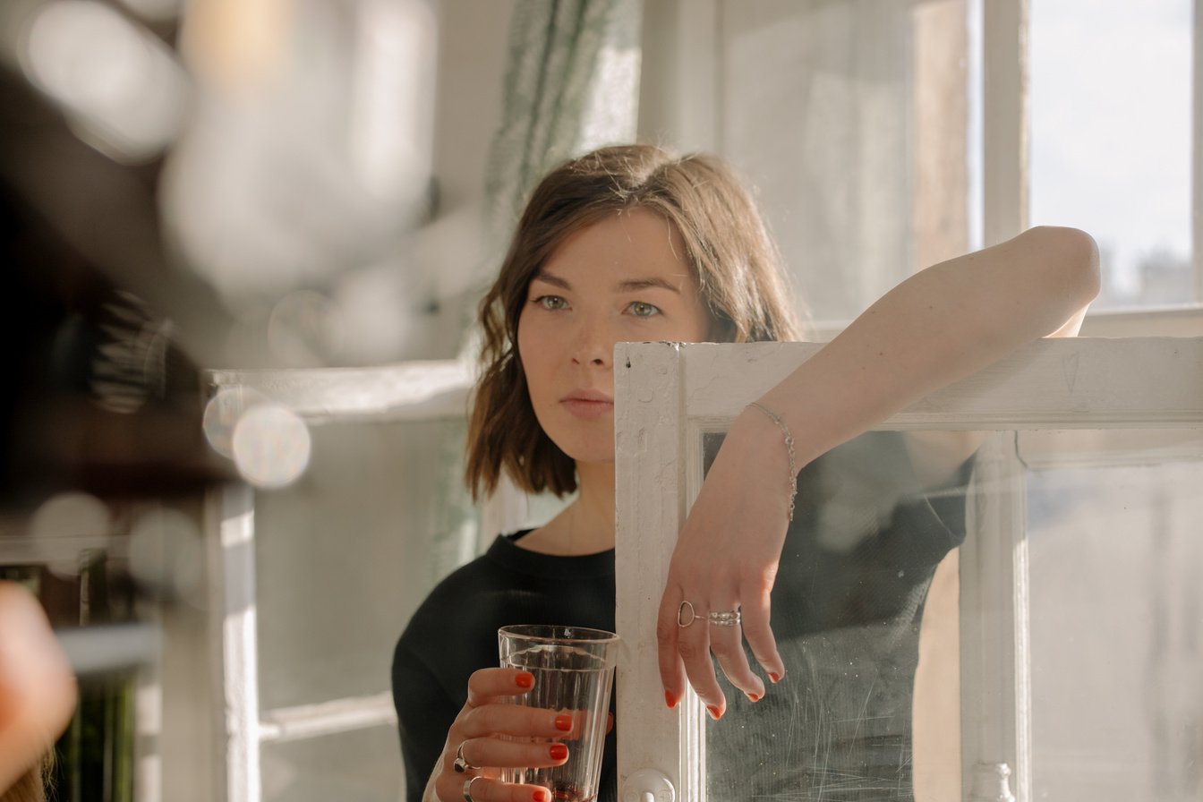 Woman in Black Shirt Holding Clear Drinking Glass